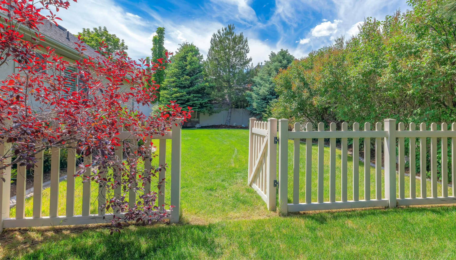 A functional fence gate providing access to a well-maintained backyard, surrounded by a wooden fence in Pittsburgh